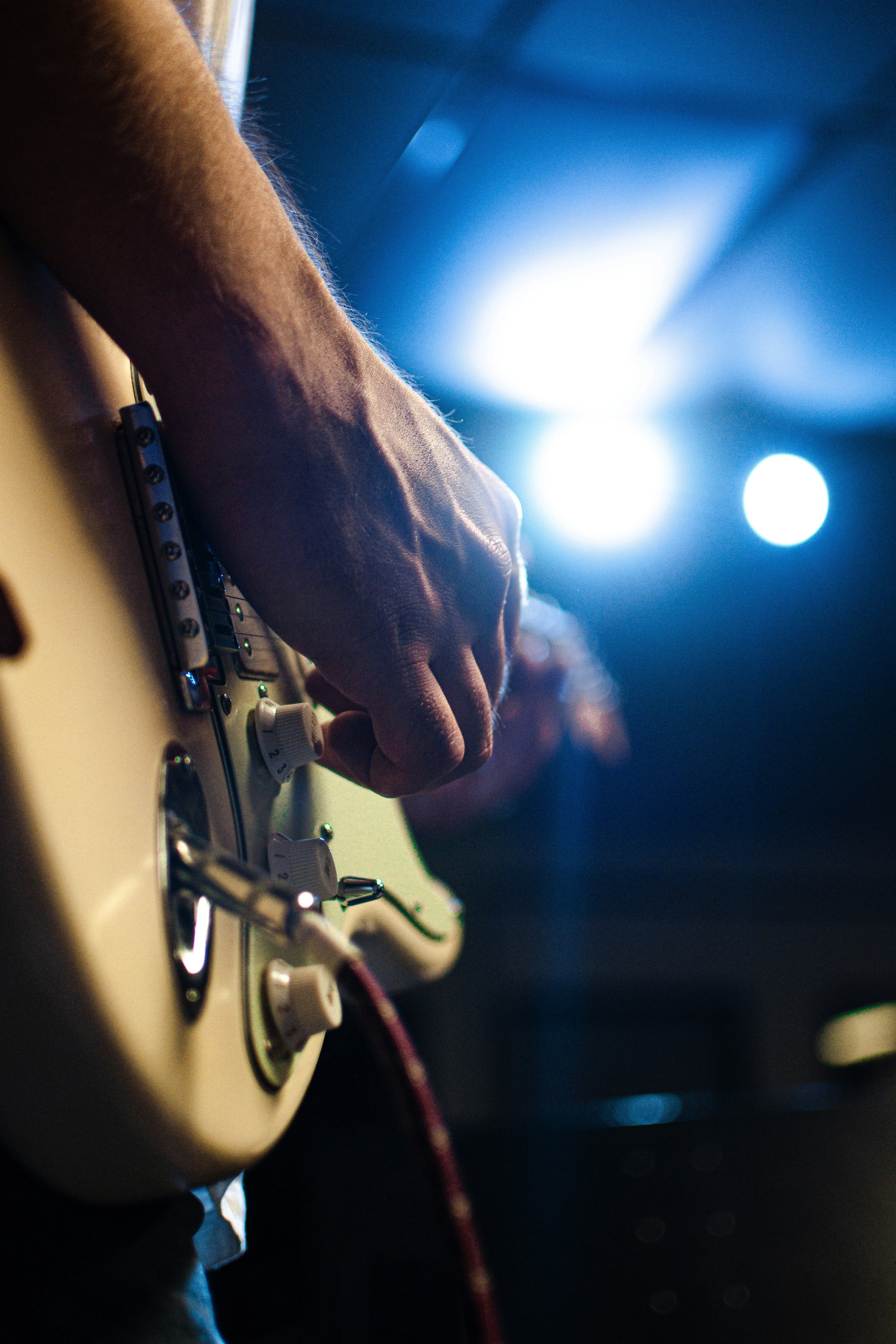 Guitarist playing an S-style electric guitar on stage — the feel and tone you're chasing when looking for a Fender alternative