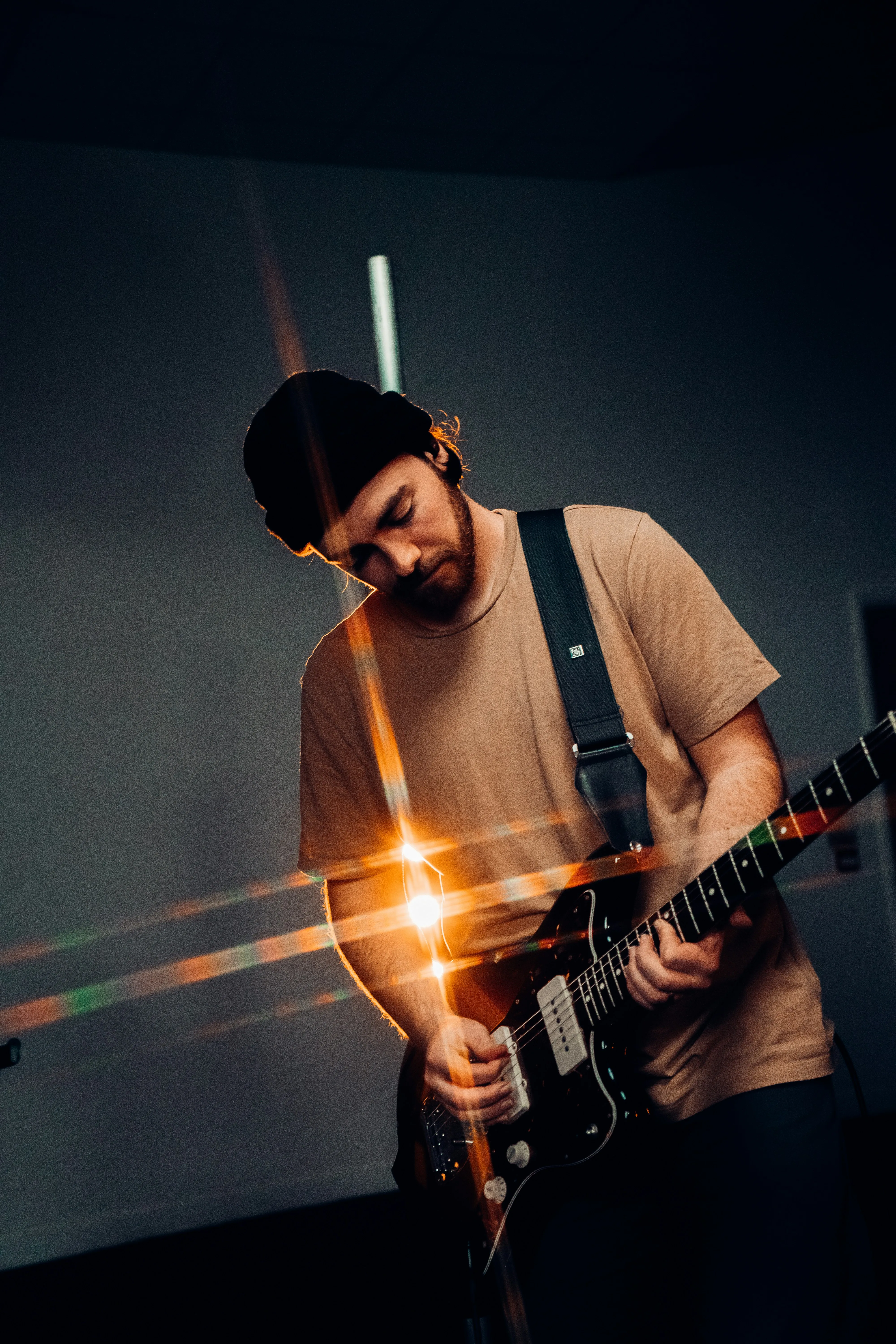 Guitarist playing with focused intensity in dramatic lighting — the moment things start to click