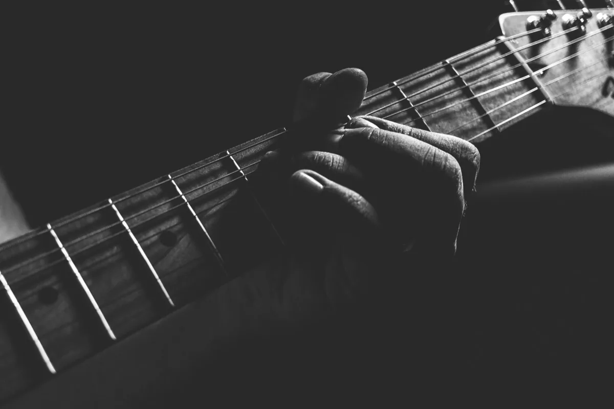 Adult beginner learning guitar chord finger positions on acoustic guitar