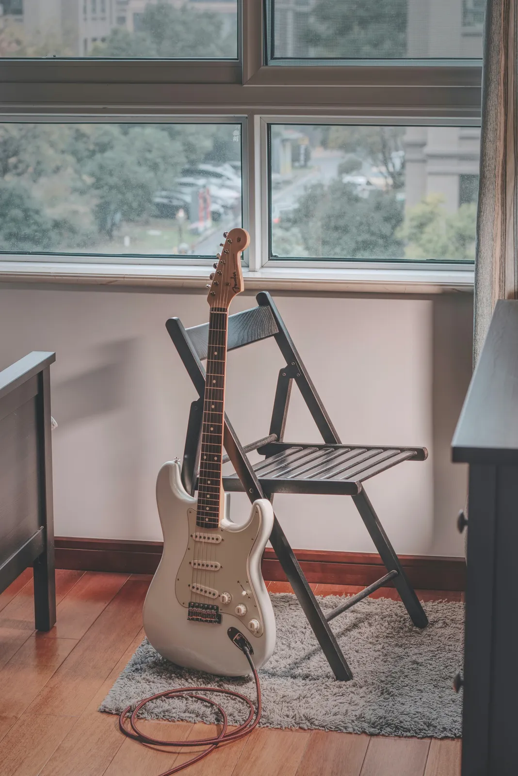Fender Stratocaster near a window — the S-style shape now named across builders from custom shops to budget brands in Thomann's lawsuit
