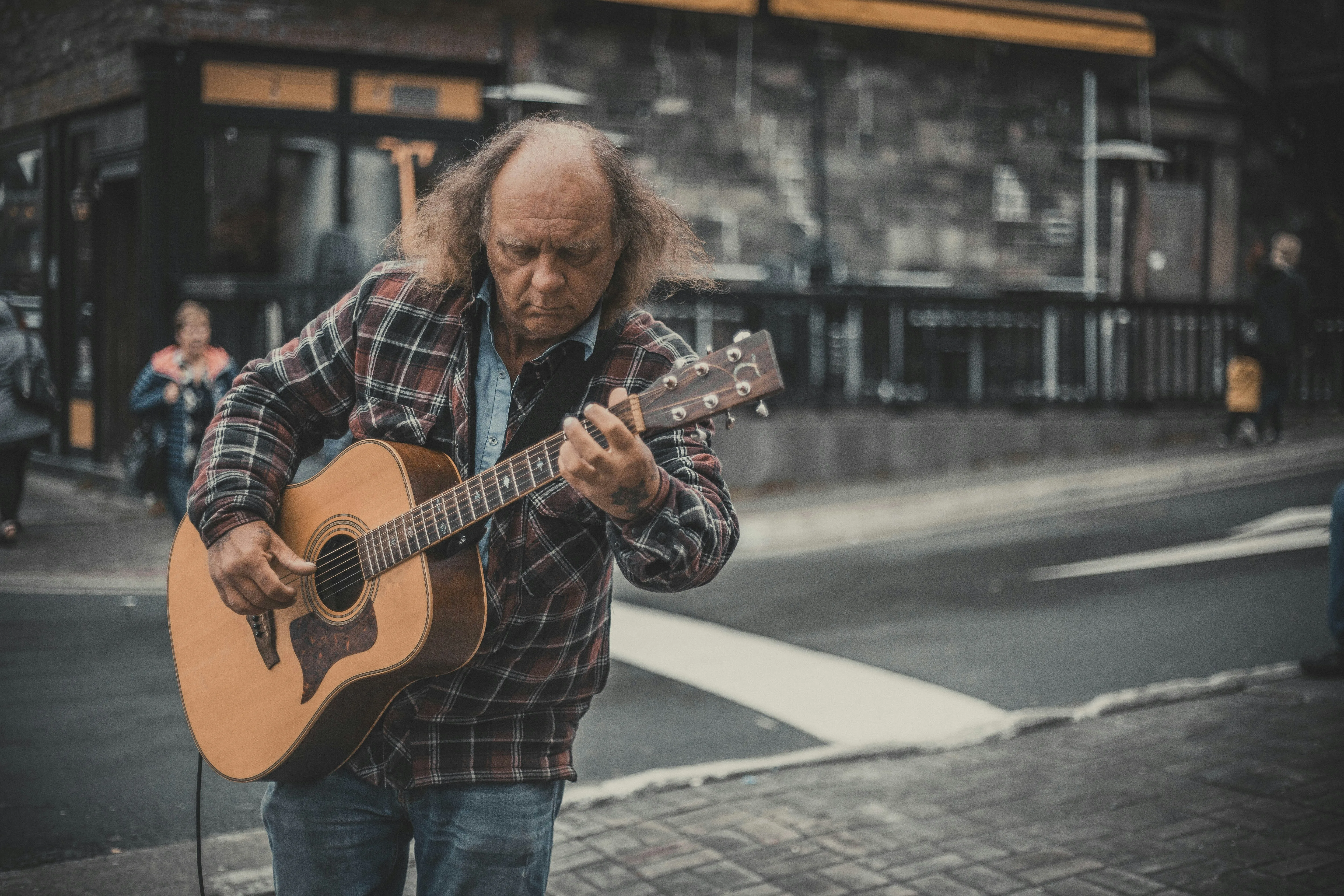 Older adult man playing acoustic guitar outdoors — learning guitar at any age