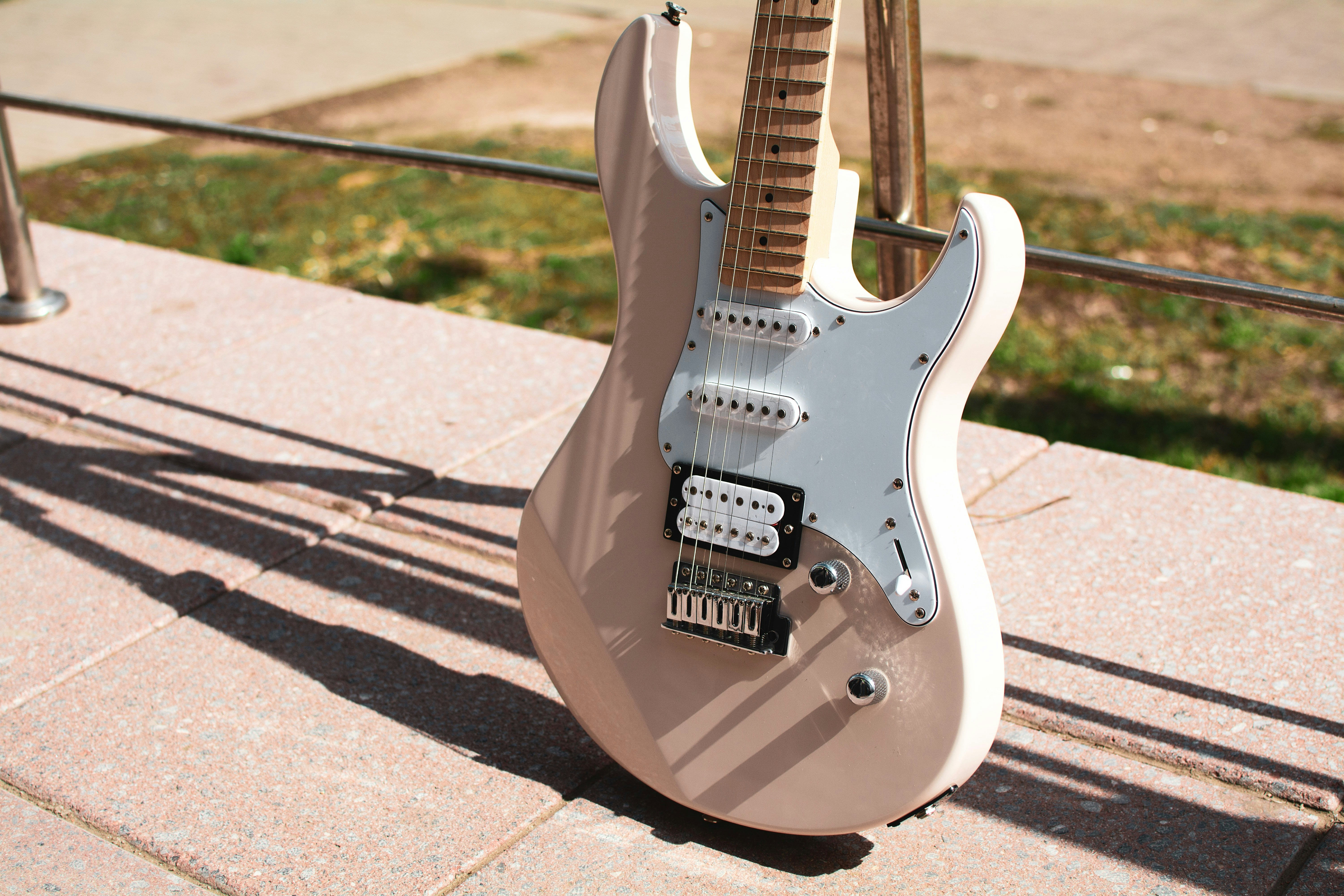 Cream S-style electric guitar outdoors — best Fender Stratocaster alternatives