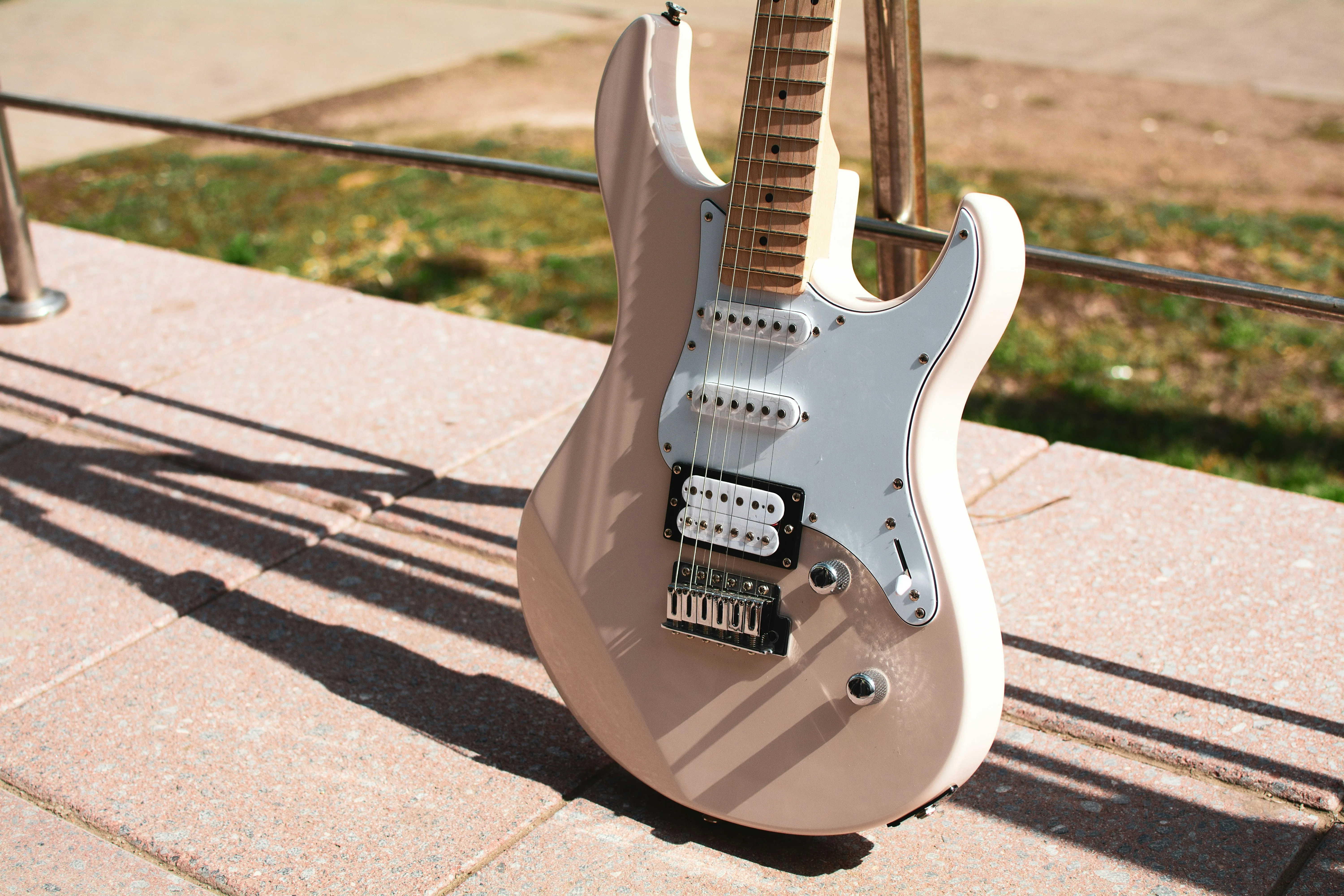 Cream S-style electric guitar outdoors — best Fender Stratocaster alternatives