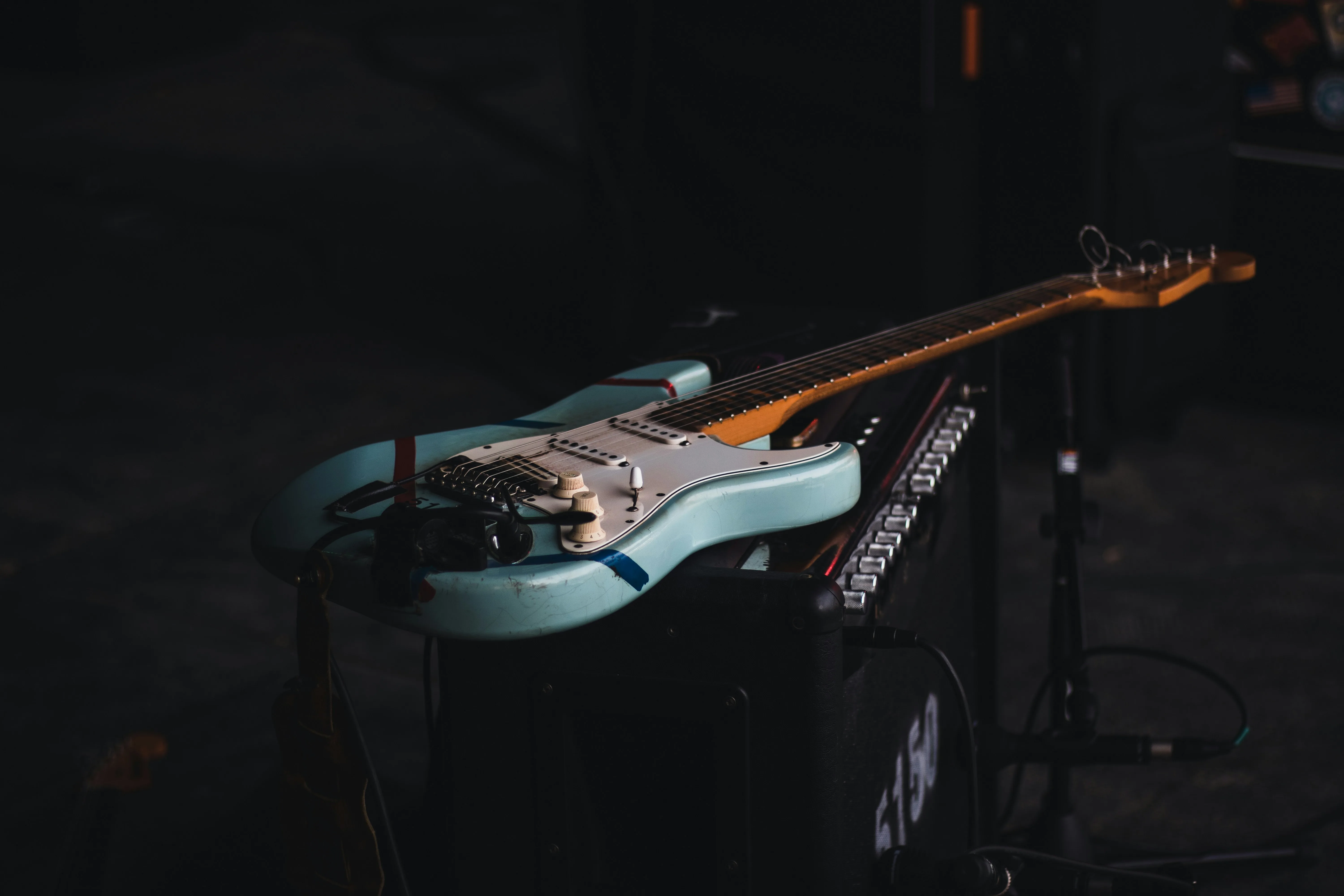 Stratocaster-style guitar resting against an amplifier — the kind of guitar Fender says it is not targeting if the design is sufficiently different